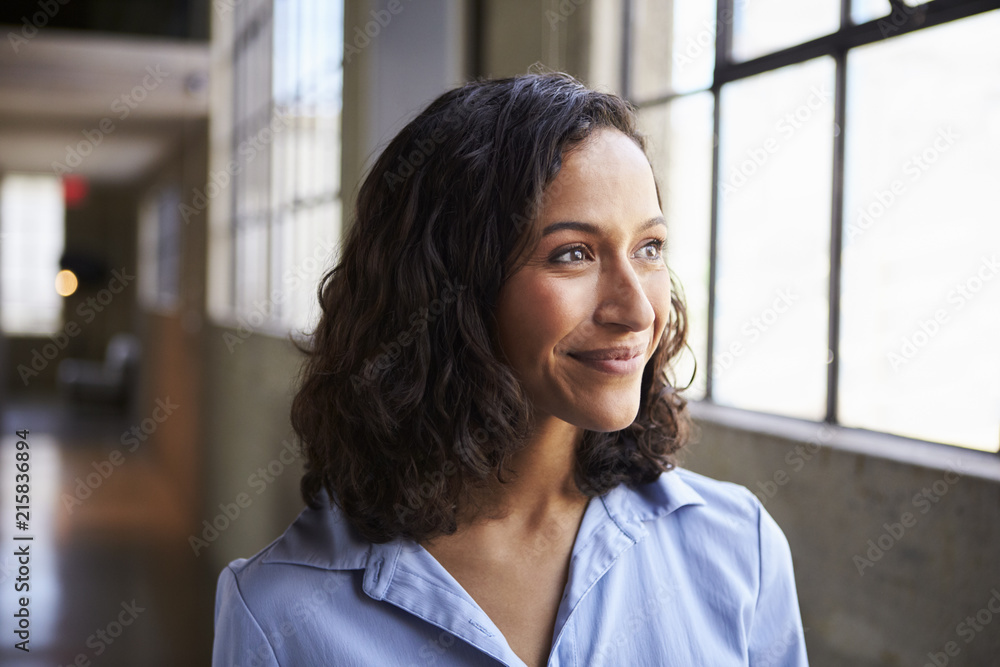 Smiling young mixed race businesswoman looking away Smiling young mixed race businesswoman looking away