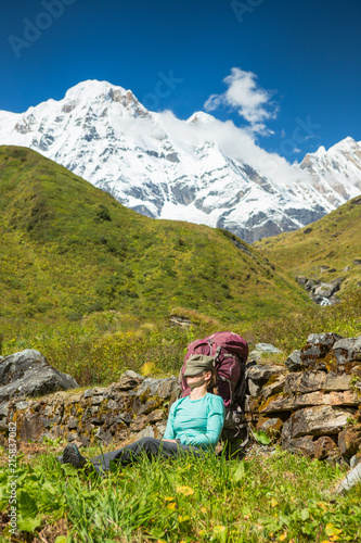Woman taking a rest in the sun before heading up valley to Annapurna Base Camp, Nepal.