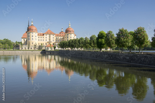 Castle Moritzburg in Saxony near Dresden in Germany surrounded by pond, reflection blue lake, blue sky