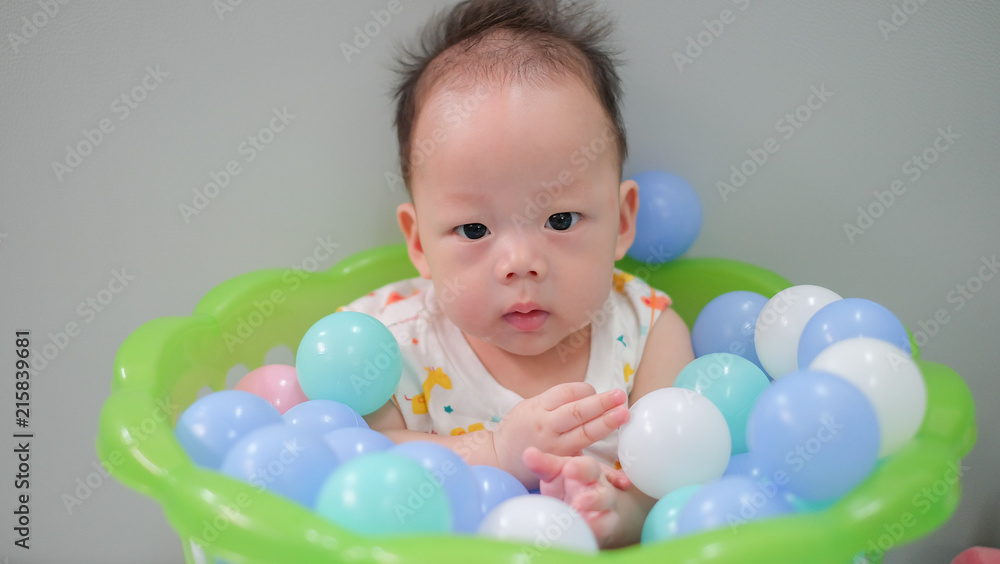 Asian baby is in the ball basket. Asian baby is in the ball basket.