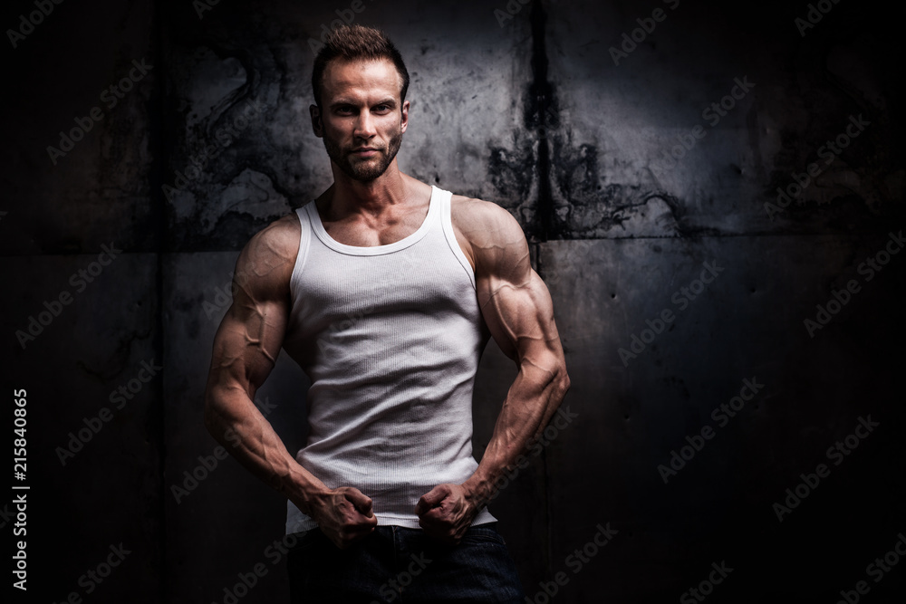 strong athletic man on dark grunge background
