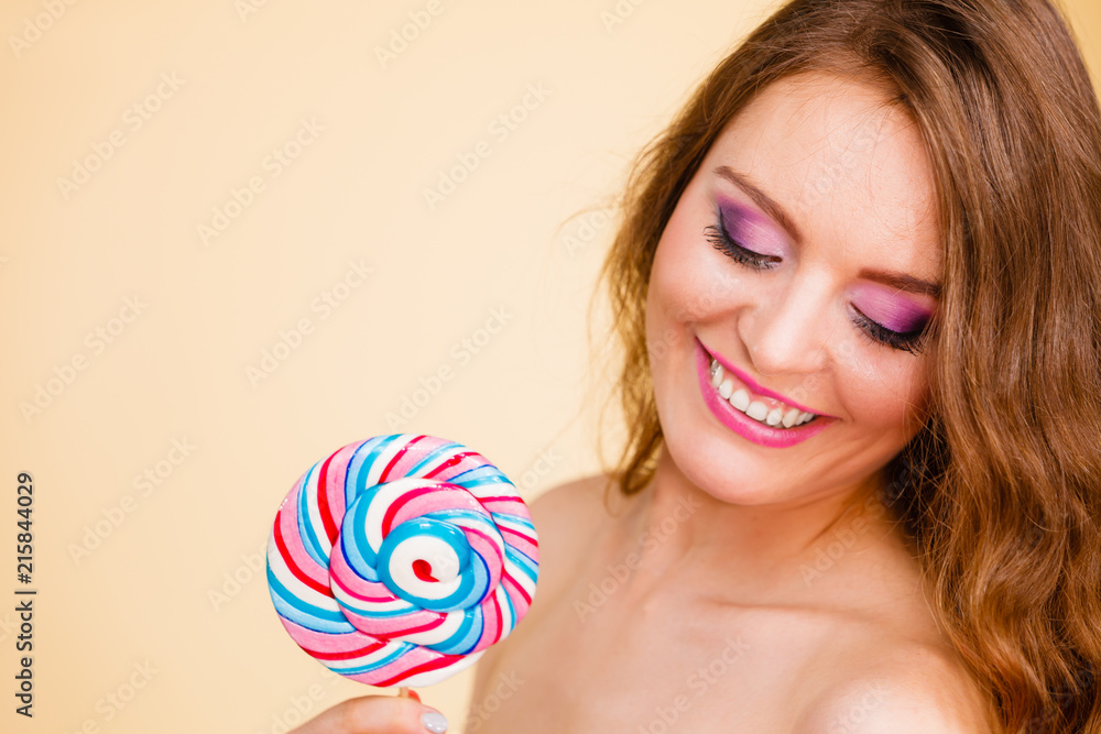 Woman holds colorful lollipop candy in hand