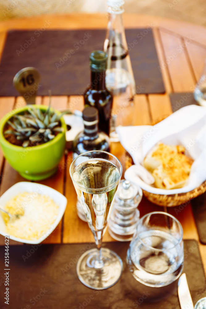 Wine and water at the table. Outdoor Italian restaurant terrace. Concept of summer authentic meal Wine and water at the table. Outdoor Italian restaurant terrace. Concept of summer authentic meal