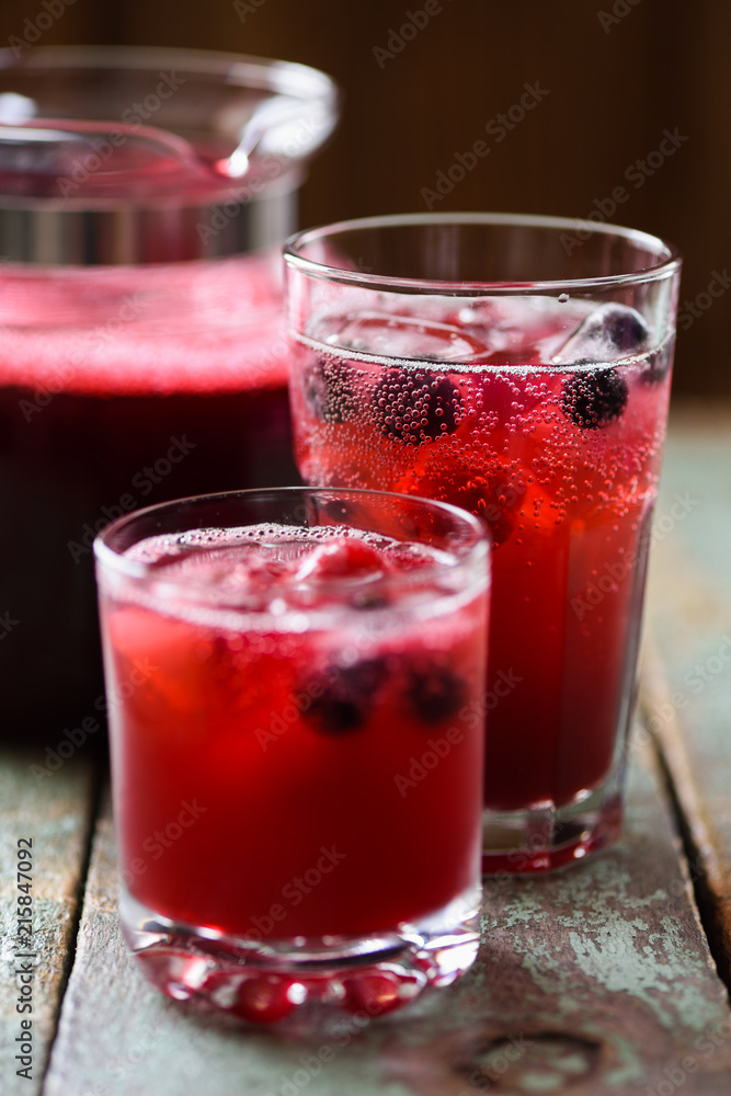 Refreshing non alcoholic beverage. Sangria, cold drink of cherry juice and soda with ice on blue background Refreshing non alcoholic beverage. Sangria, cold drink of cherry juice and soda with ice on blue background