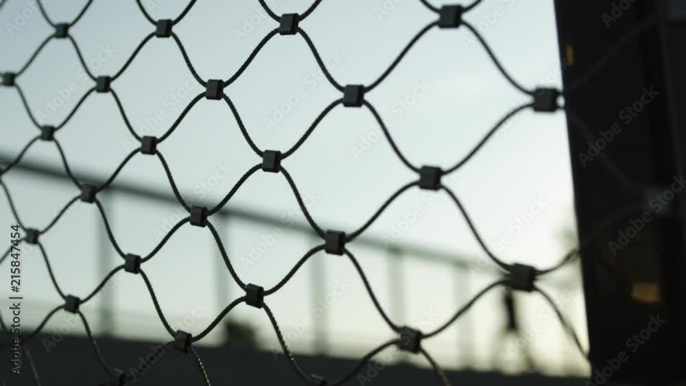 Travelling shot from a Freerunner running behind a fence, blurred and in slow-motion. Travelling shot from a Freerunner running behind a fence, blurred and in slow-motion.