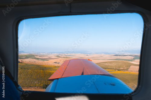 Airplane window view over fields 