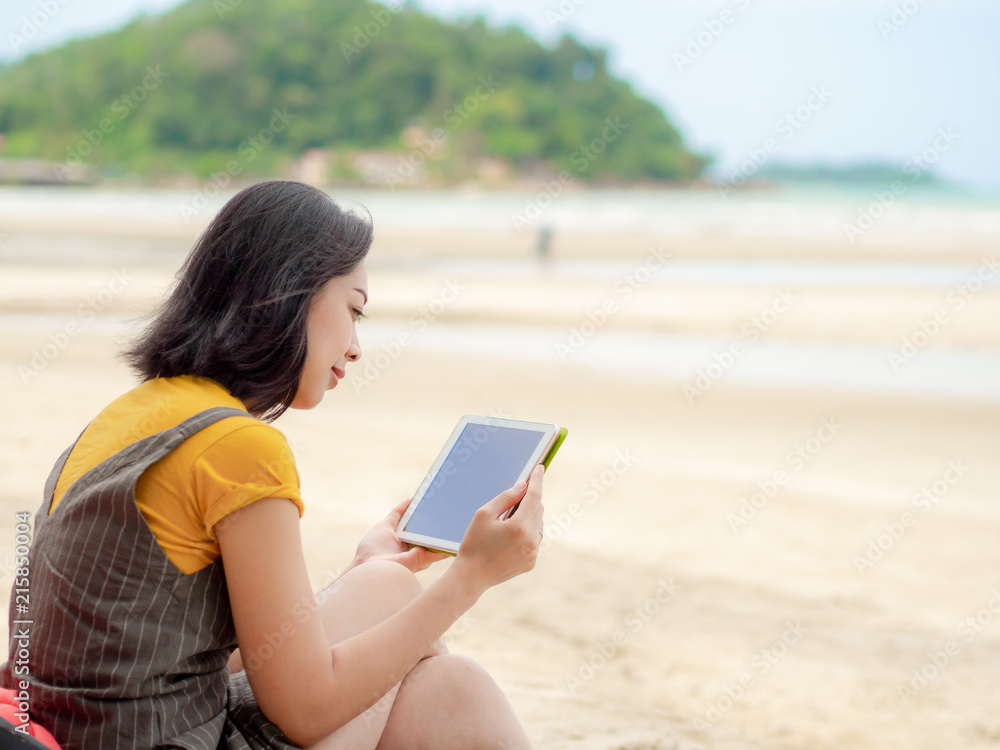 Woman use tablet while relax on the beach in summer.