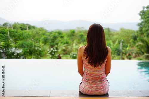 woman sit by the pool.