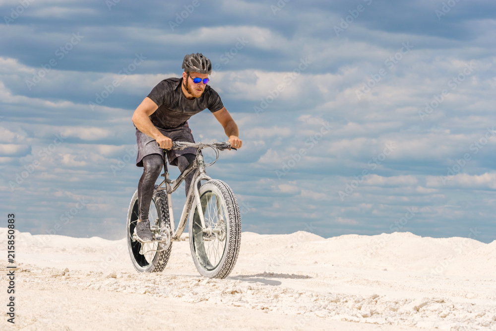 Fototapeta premium Training a bicyclist in a chalky quarry. A brutal man on a fat bike.