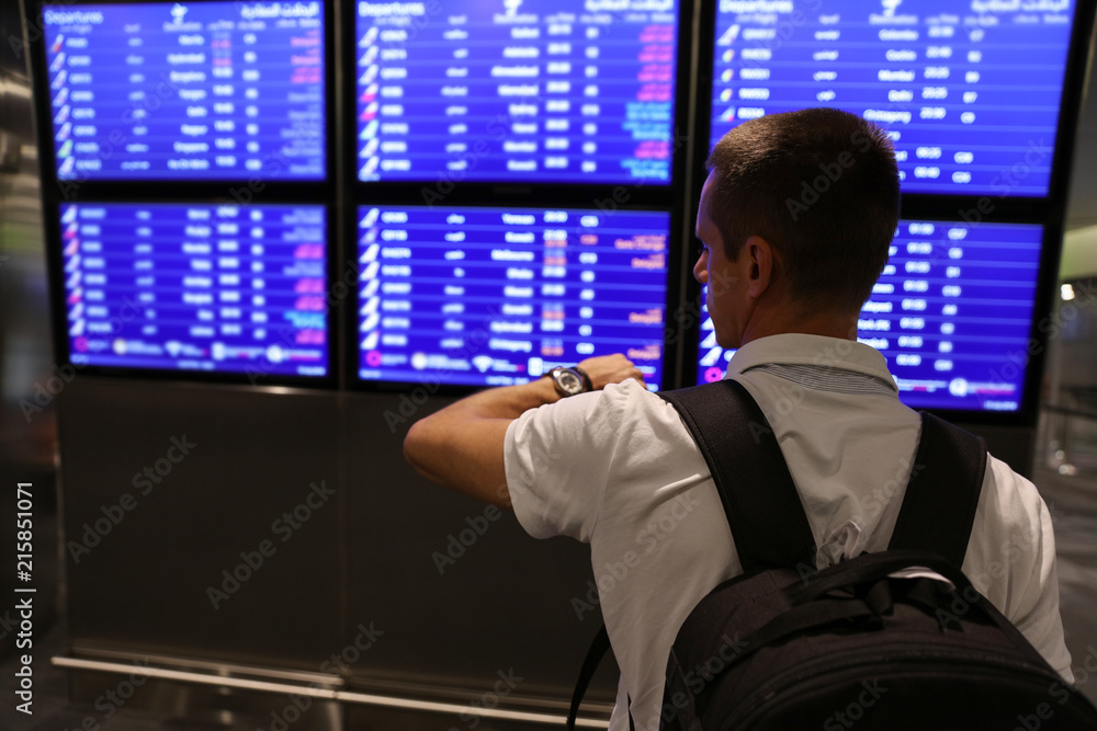 Fototapeta premium Traveling man waiting for a flight at airport late at night, businessman using mobile phone. Transit, Connecting flihgts