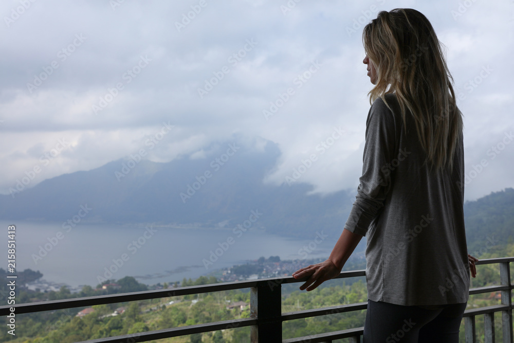 Happy active fitness girl travel concept. Young woman enjoying summer holiday and Mount Batur Volcano view on Bali, Indonesia