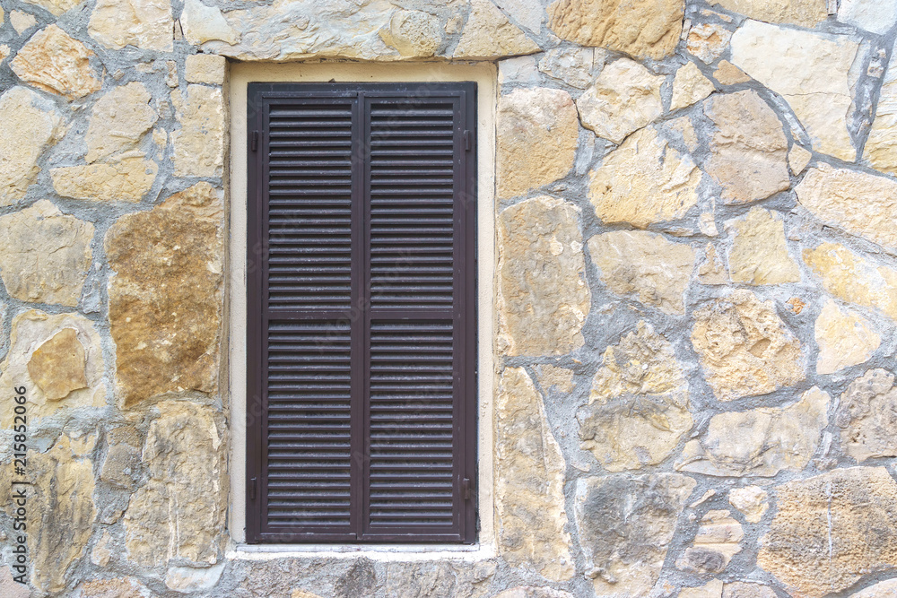 Window with blinds in the stone wall Window with blinds in the stone wall
