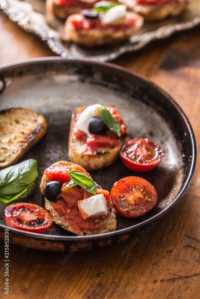 Bruschetta toast with mozzarella tomatoes olives and basil. Bruschetta toast with mozzarella tomatoes olives and basil.
