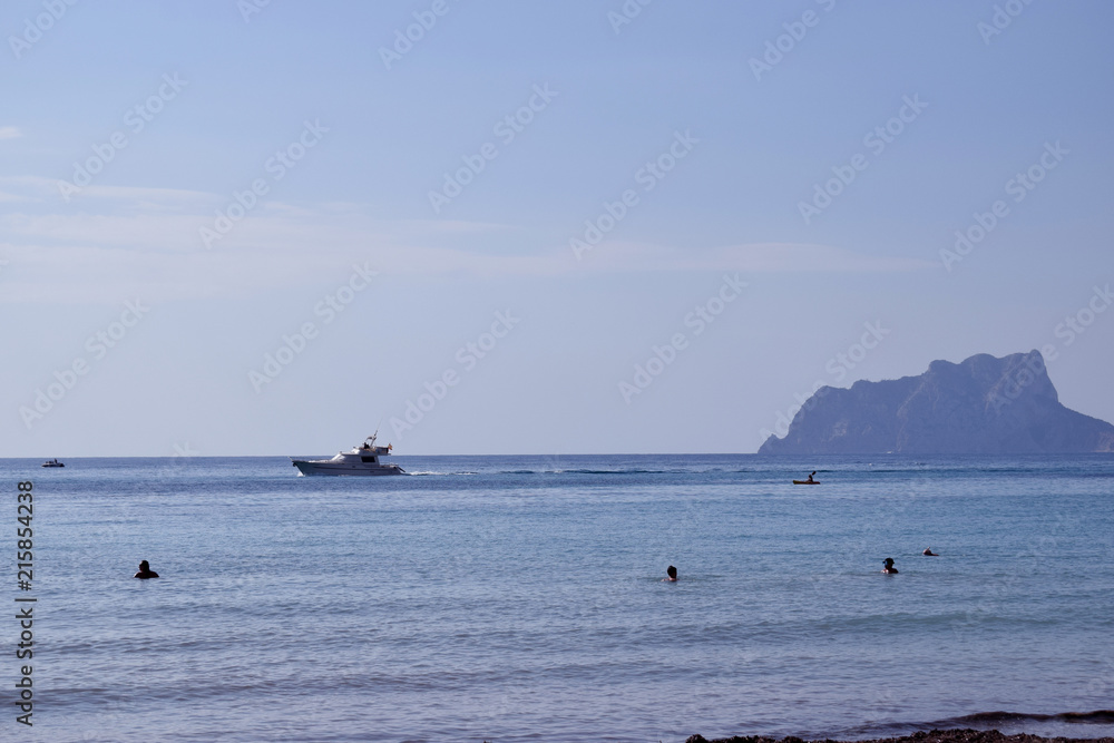 A beautiful sea view, speedboat and mountain Ifach on a blue sky background