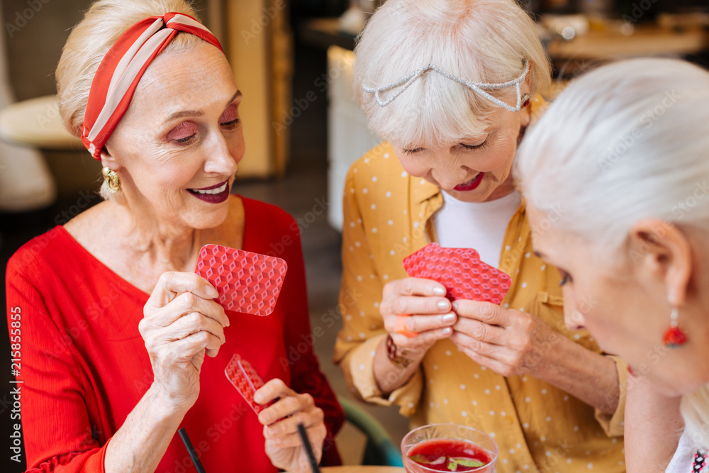 My turn. Pleasant happy woman holding a card while making a move