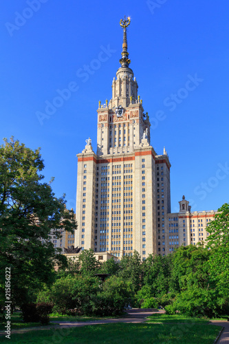 Building of Moscow State University (MSU) against blue sky and green trees in the park in sunny summer evening