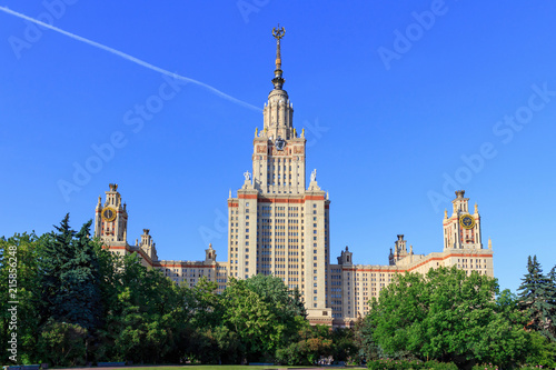 Buildings of Lomonosov Moscow State University (MSU) against blue sky and green trees in sunny summer evening