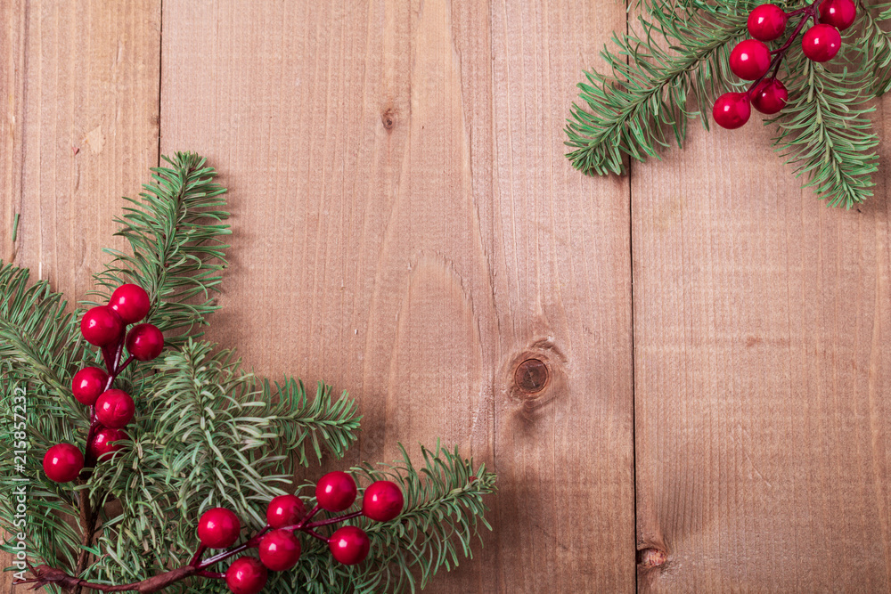 Christmas fir tree on wooden background. Red berries. Rustic style. Top view. Copy space. Christmas fir tree on wooden background. Red berries. Rustic style. Top view. Copy space.