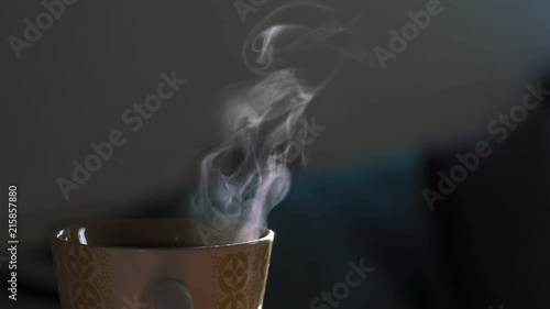 Humo blanco de taza con café en fondo oscuro