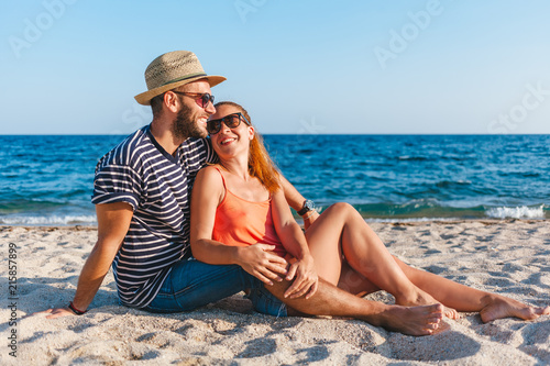 Young couple in love lying on the beach enjoying