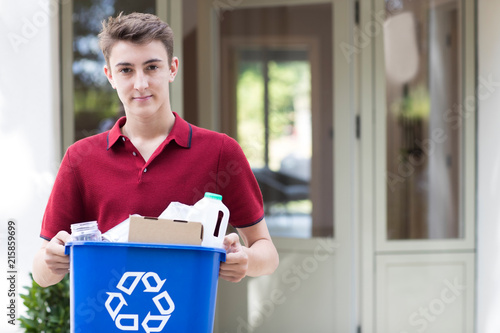 Canvas Print Portrait Of Teenage Boy Outside House Carrying Recycling Bin