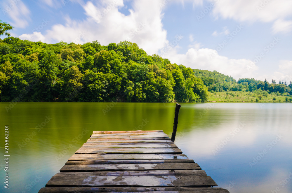 Wooden pier or jetty and a boat on lake sunset and sky reflection water. Wooden pier or jetty and a boat on lake sunset and sky reflection water.