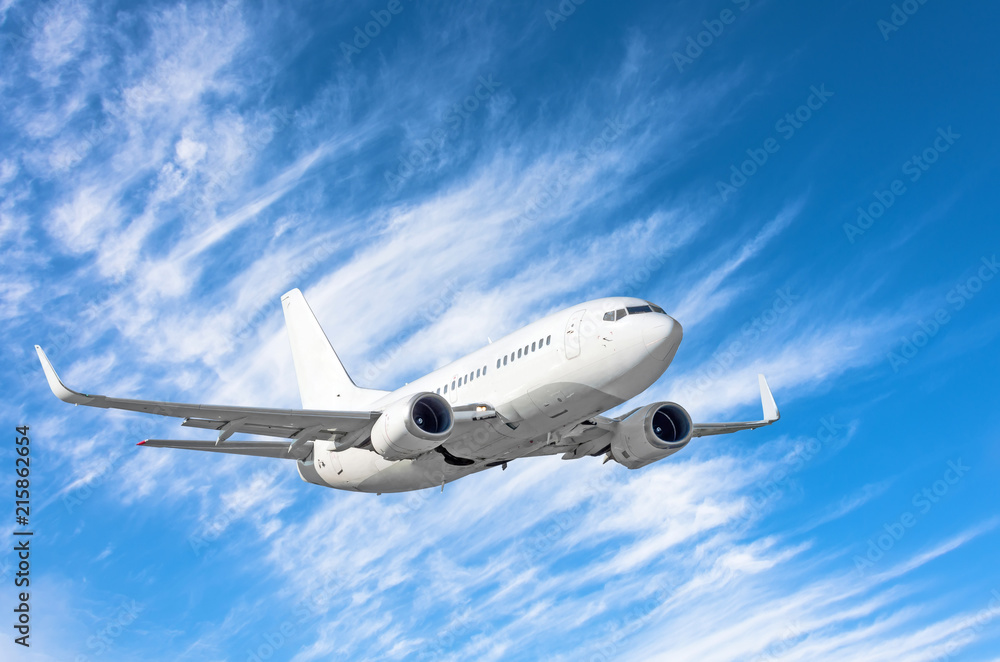Fototapeta premium Flying passengers aircraft fly climb on a background of blue sky and cirrus clouds.