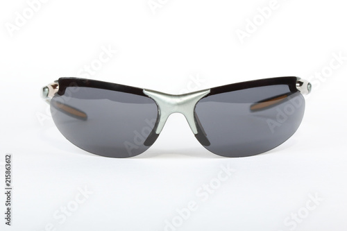 Old sport sunglasses with silver plastic frame and a gray glass on a white background