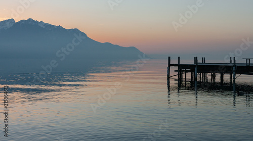 Panoramic view at old wooden jetty and alps on the shores of lake Geneva during sunset in Montreux, Switzerland