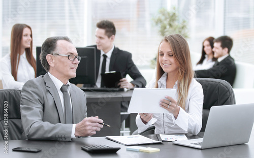 employees using digital tablet to work with financial data