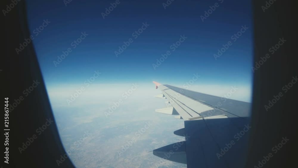 View through the airplane's window, wing, clouds, blue sky nature View through the airplane's window, wing, clouds, blue sky nature