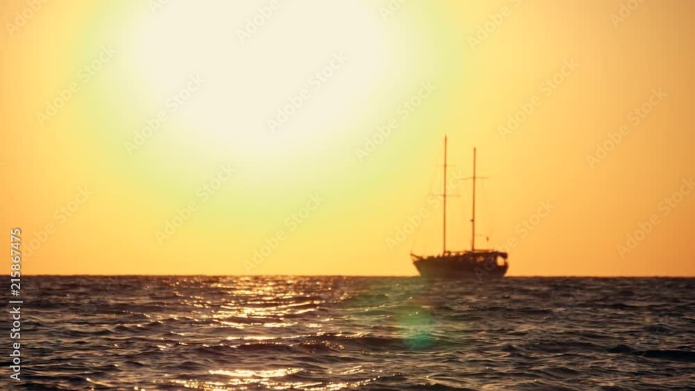 Sailing yacht in the open sea at sunset, rocking on the waves Sailing yacht in the open sea at sunset, rocking on the waves