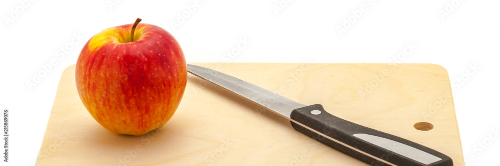 Red juicy apple and knife on a cutting board made of light wood. Red juicy apple and knife on a cutting board made of light wood.