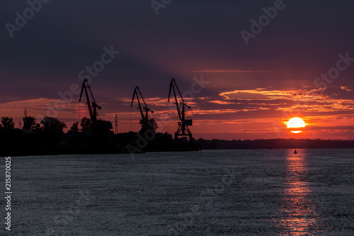Port cranes and a bloody sunset over the river © 70200