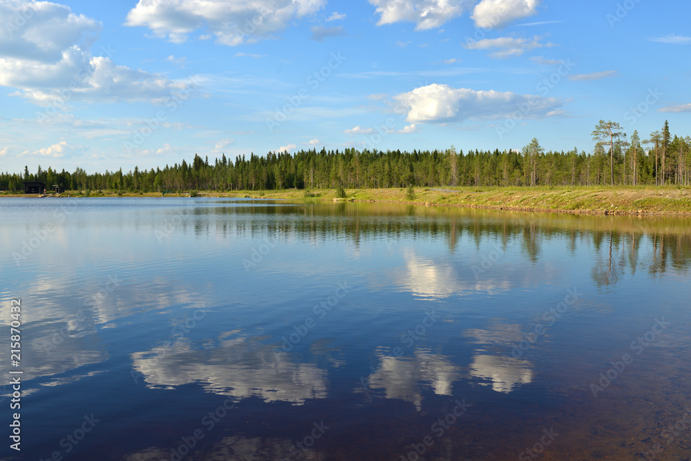 Summer landscape. Picturesque lake with reflection of clouds in Finnish Lapland