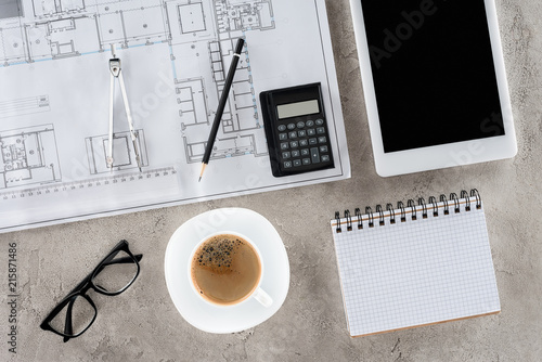 top view of architect workplace with blueprint, divider, coffee and digital tablet with blank screen