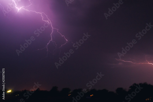bright flash of lightning illuminated the night sky and dyed clouds in a blue violet color