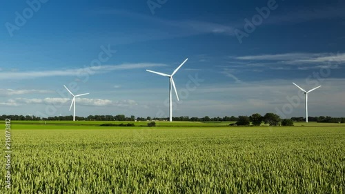 Time lapse of spinning wind turbines for electrical power generation with cloudy sky in Normandy, France. Modern technology of environment friendly energy production