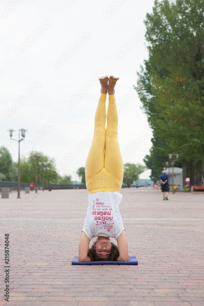 Obraz premium Beautiful woman doing Vriksasana pose on yoga class