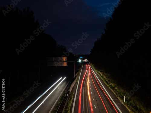 Light trails of driving cars under the bridge at night
