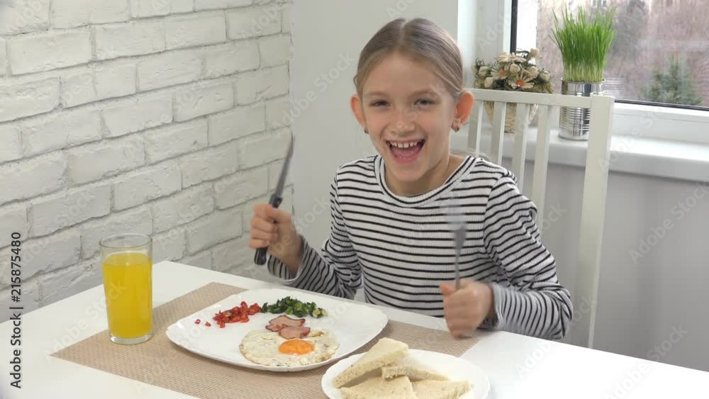 Happy Child before Eating Breakfast in Kitchen, Laughing Girl with Healthy Food Happy Child before Eating Breakfast in Kitchen, Laughing Girl with Healthy Food