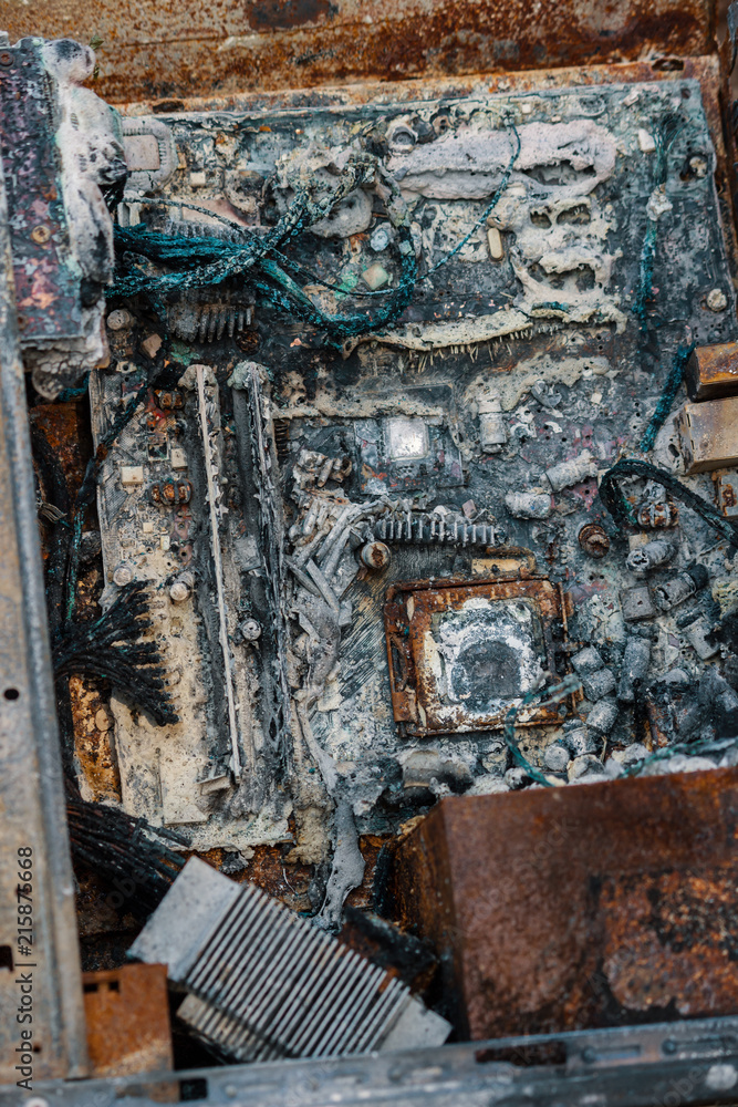 Closeup of a burned desktop computer. Burned computer parts, scorched elements of the motherboard. Completely destroyed machine, rendered useless.