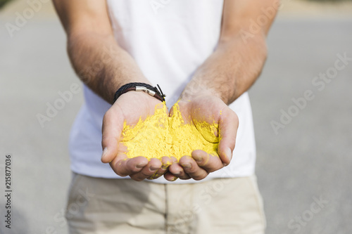 Male hands holding yellow powder photo