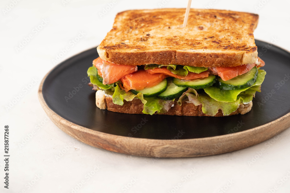Sandwich with cereals bread and salmon on dark marble background. Copy space. Sandwich with cereals bread and salmon on dark marble background. Copy space.