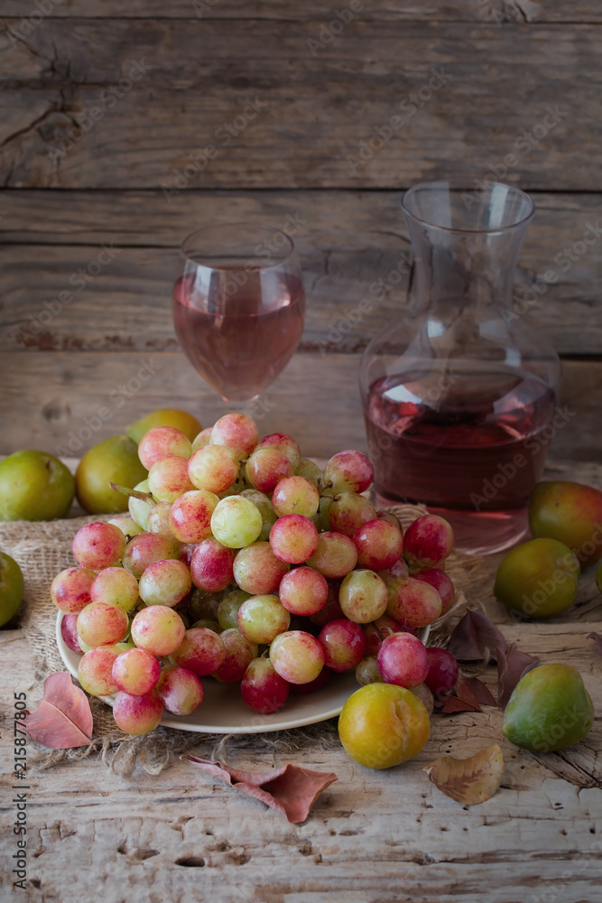 Rose wine with grapes and plums on wood rustic background. Rose wine with grapes and plums on wood rustic background.