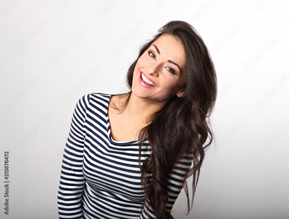 Happy emotional woman toothy smiling and looking in stripped casual clothing on blue background Happy emotional woman toothy smiling and looking in stripped casual clothing on blue background