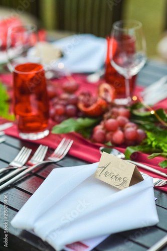 inscription of the calligraphy of the guest s name on a card on a plate. A red table decorated table for the event.