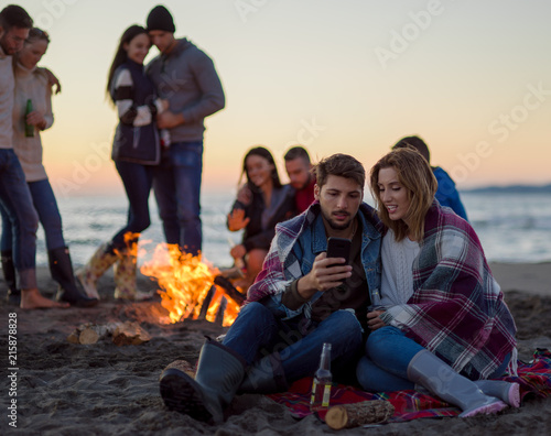Couple enjoying bonfire with friends on beach © .shock