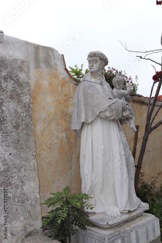 A Sculpture of  Saint Anthony of Padua In the gardens of the Carmel Mission Basilica in Carmel, California which was originally in Venice, Italy. 