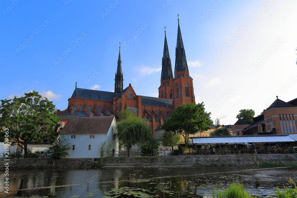 Gorgeous view on town street with cathedral on background. Gorgeous blue sky with white clouds on a summer day. Tourism / travel concept. Europe, Sweden, Uppsala.